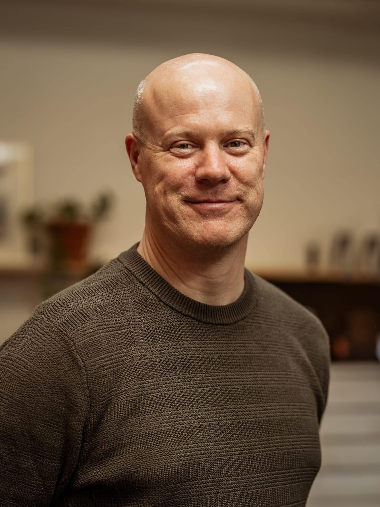 A bald man smiling in an office.